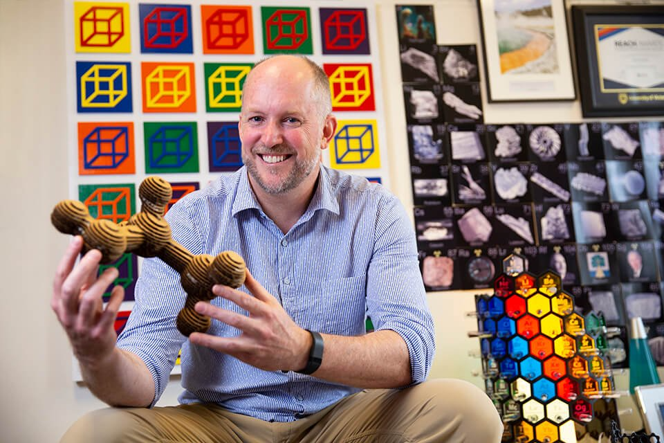 Scott McIndoe holds 3D model of a molecule