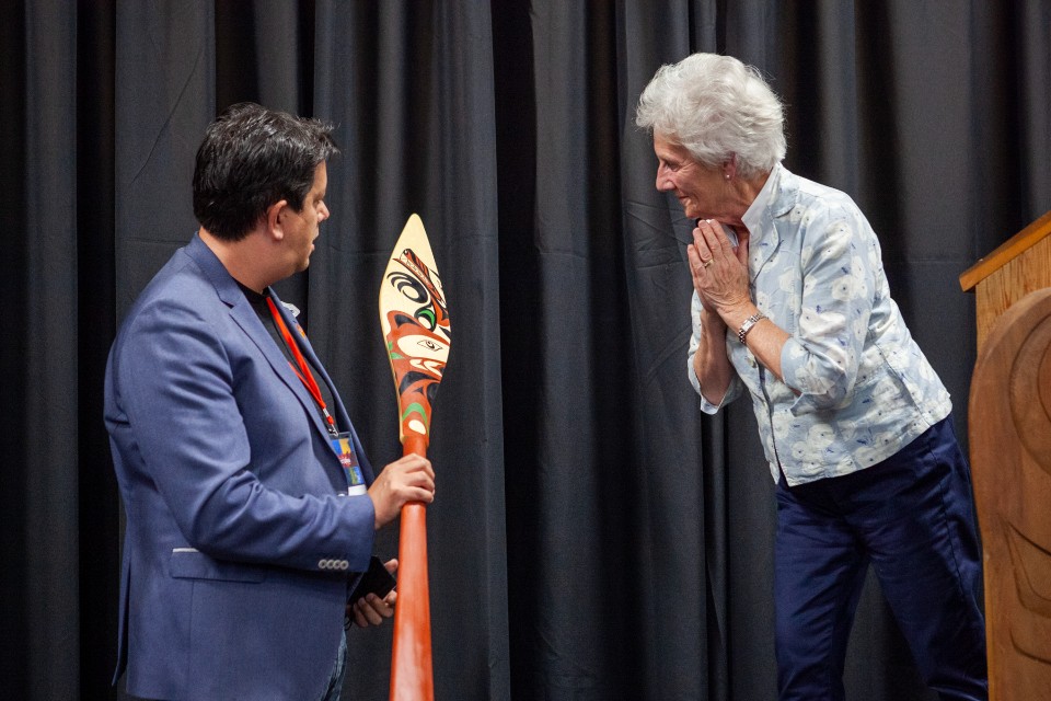 Carey Newman holds a hand-carved paddle 