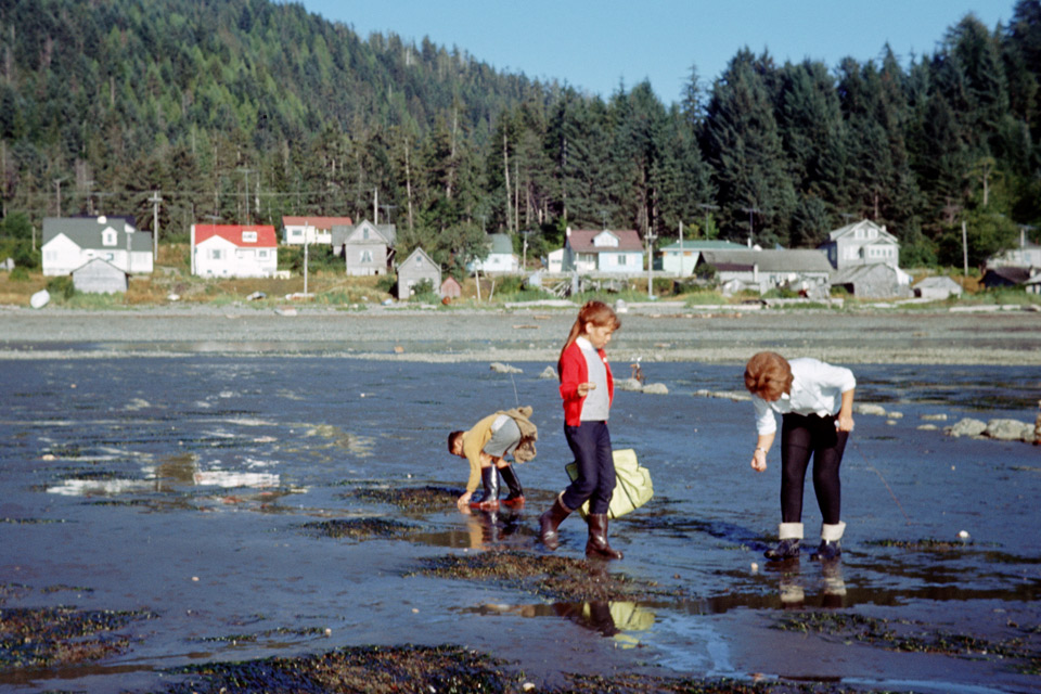 Parrish standing on a beach digging for clams.