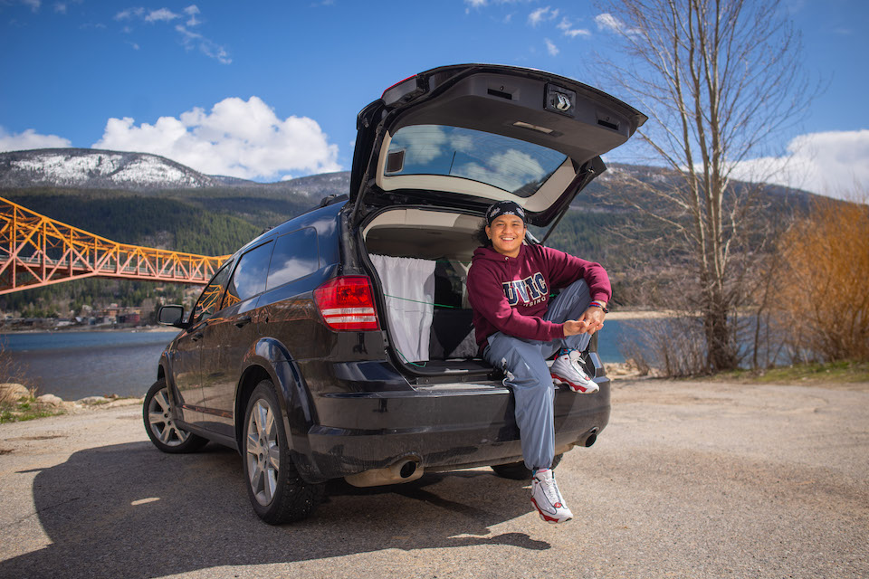 James stands proudly with the car he was able to purchase and use for travel to practicum placements, thanks to donor funds. Photo Credit: Adrian Wagner Studio.