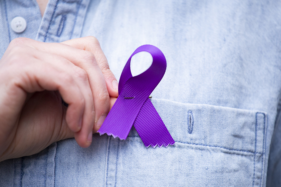 Purple ribbon pinned to blue-jean lapel.