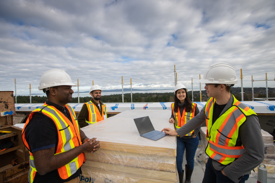 Members of the ReBuild team discuss energy efficient materials being installed on a University of Victoria rooftop. L to R: Rajeev Kotha, Haris Shamsi, Mahsa Torabi and Ralph Evins. Credit: Armando Tura