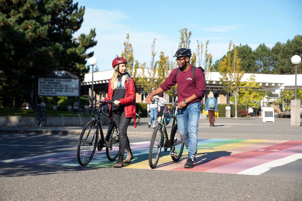 Students walk their bikes across UVic campus