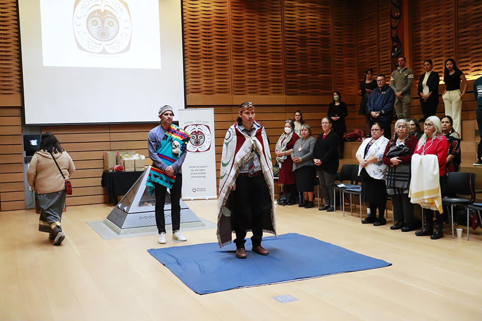 Indigenous artist, Qwul'thilum, Dylan Thomas is wrapped in a blanket to be honoured during a blanketing ceremony in the First Peoples House.