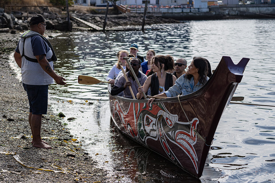 IGOV students in a canoe ask Songhees Elders if they could come ashore.