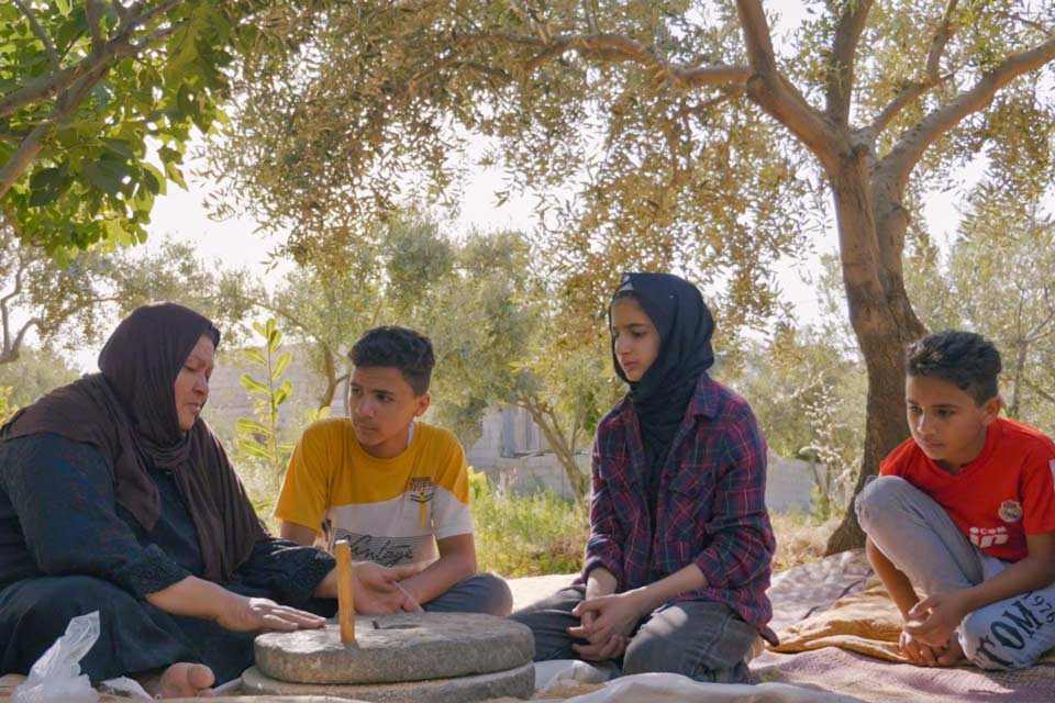 Azzam with three of her grandchildren and the family millstone