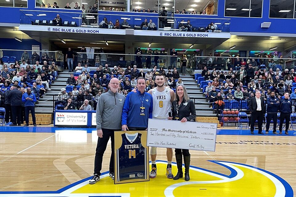 Vikes men's basketball alumnus Geoff McKay presents $250,000 cheque to representatives from UVic and the men's basketball team.