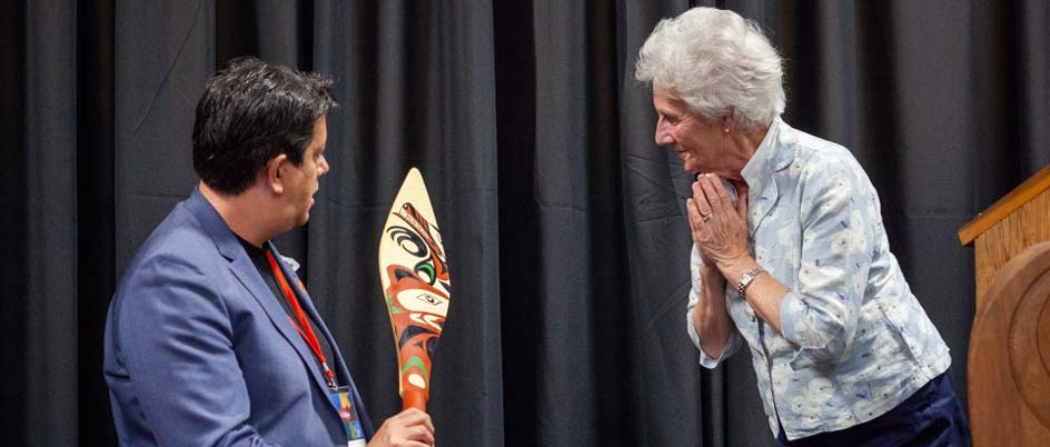 Artist Carey Newman presents a hand-carved paddle to a member of the Victoria Forum