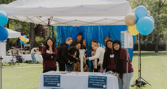 Students taking photos at a photo booth with student leaders.