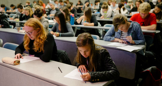 Students writing a test in a lecture hall