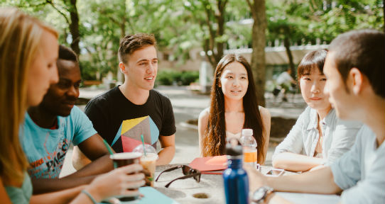 Group of students hanging out at an outdoor table