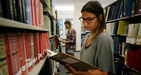 Student reading a book in the library