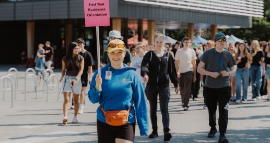 Student holding sign that says First Year Residence Orientation
