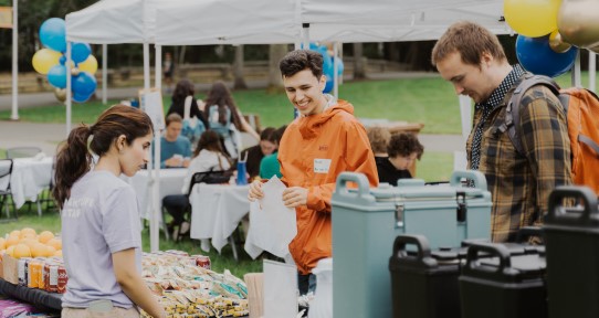 Students getting refreshments and talking with other students.