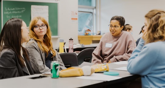 Students sitting around a table working together.