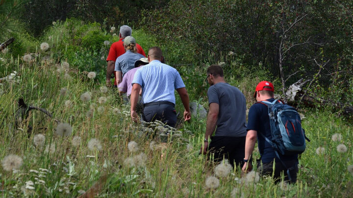 6 people hiking through a meadow