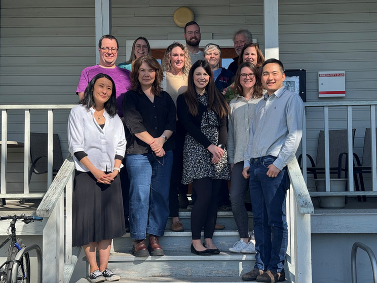 Group photo of the THRIVE program participants, including award recipients, mentors, and the IALH Director (center), standing together on the steps of a white wooden building during their final lunch gathering