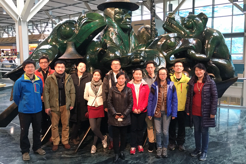 Early Career Leaders in China program pose in front of First Nations jade statue in Vancouver airport