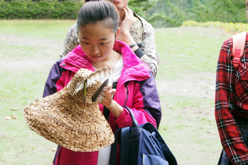 IYLP participant examining a First Nations woven cedar hat