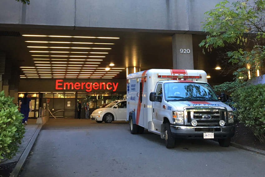 photo of ambulance parked outside a hospital emergency entrance