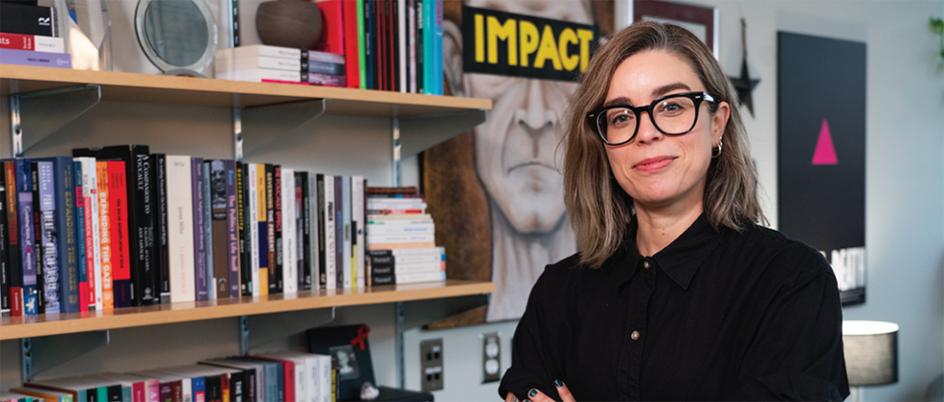 An image of Marilou Gagnon standing in front of a colourful bookshelf