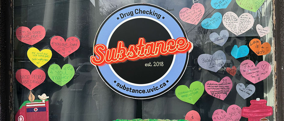 An image of the Substance drug checking window. A round Substance logo is in the middle, surrounded by pink and red paper hearts