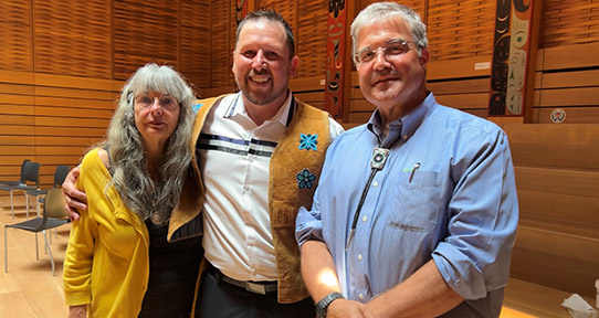 A photo of Joan Johnson (left), Jarret Nelson (centre) and Tim Naimi (right) in the First People's House at UVic