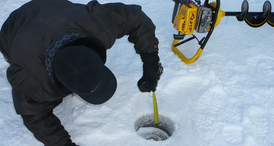 Researcher measuring ice depth