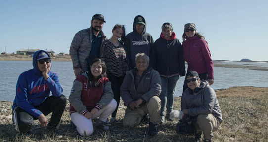 A group of people standing next to the Arctic Ocean