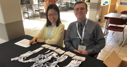 Former Research Assistant Madeleine and Student Affiliate Jeremy running a table at a CFYS event.