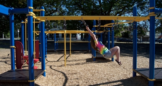 Girl swinging on monkey bars