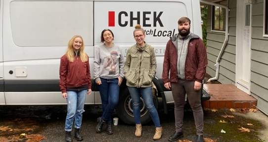 Four young adults standing in front of a white CHEK News van next to the Centre for Youth & Society