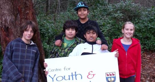 Youth participants at an event holding up the CFYS sign