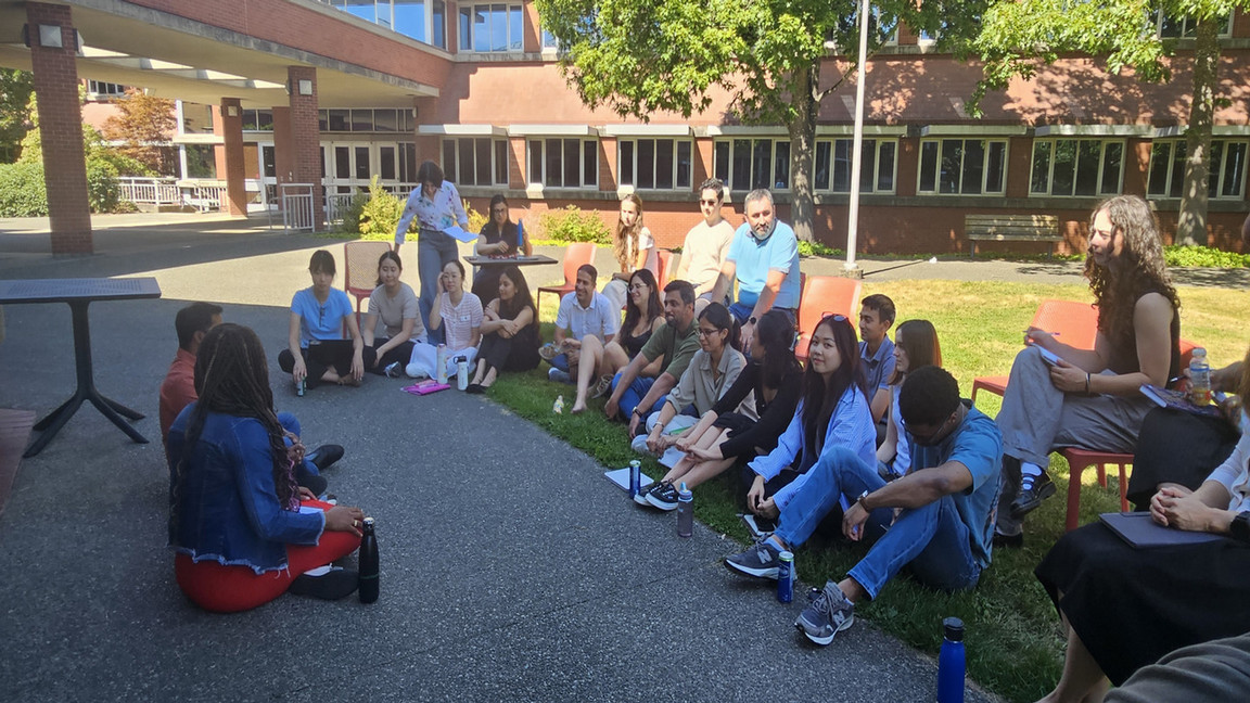 Students from the Impact Investing Summer School sitting in a circle outside during summer.
