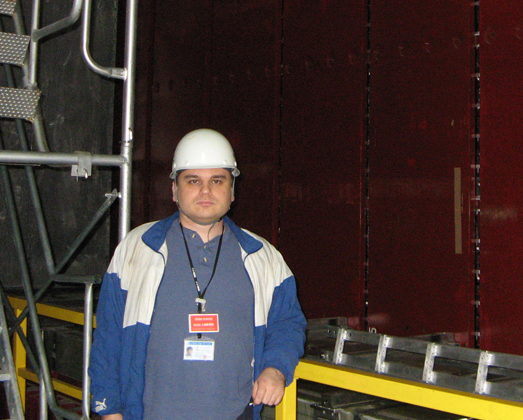 Myslik standing next to one of the open halves of the magnet that the ND280 detector is now inside.