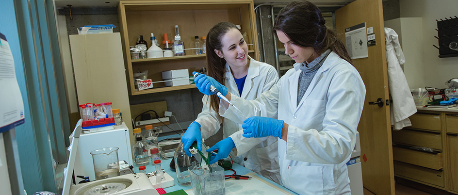 Graduate student Chloe Christensen and another woman in a biology lab