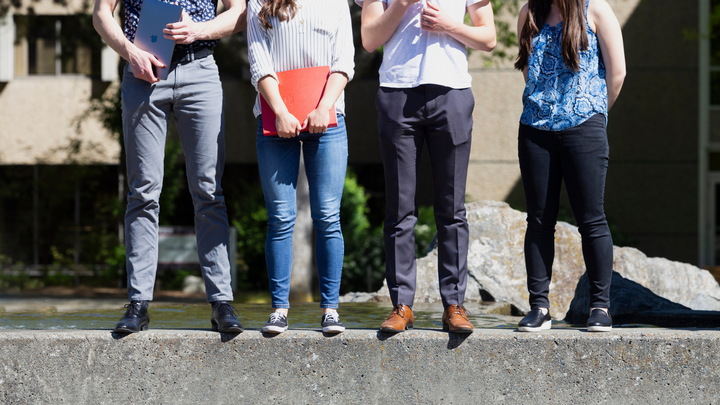 Legs of students on the fountain.
