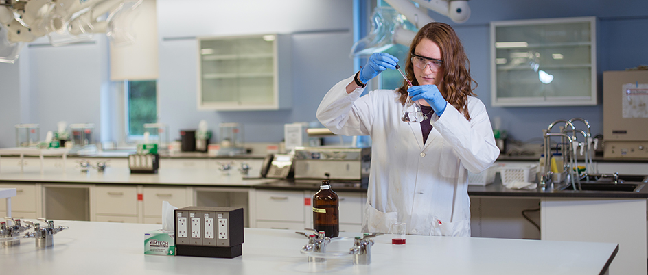 UVic student in a chemistry lab holding a dropper and beaker