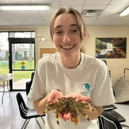 Hannah holding a crab in a classroom