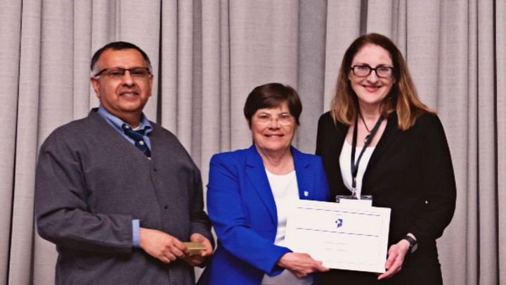 Dr. Cameron receiving an award from two members of the Canadian Academy of Health Sciences
