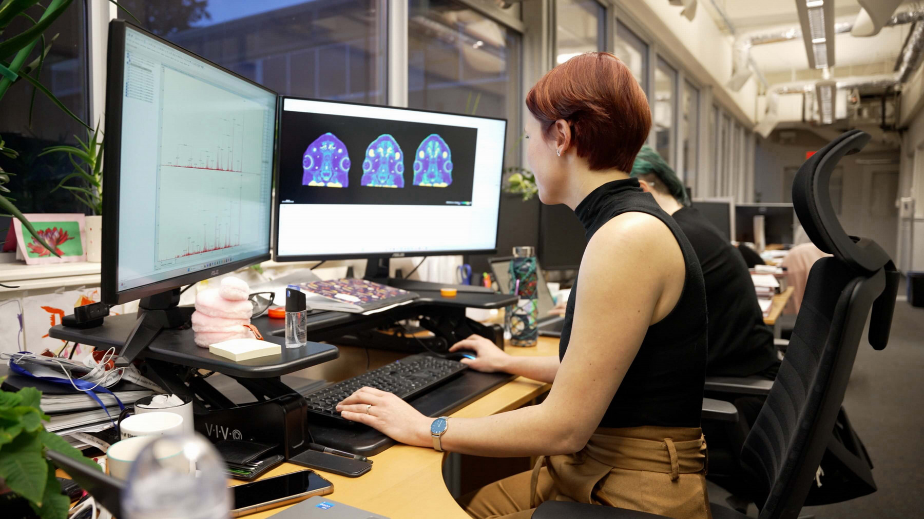 Scientist sitting at a desk imaging proteomis data on a computer