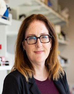 Headshot of Dr. Caroline Cameron. Blurred lab in background.