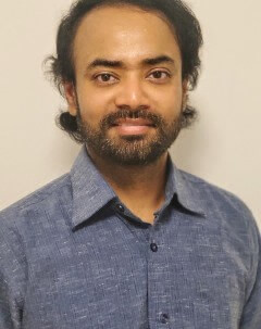 Smiling headshot of Dr. Aditya Mojumdar in front of a neutral background.