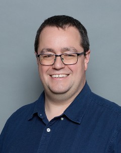 Head shot of Dr. Tuffs on neutral grey background.