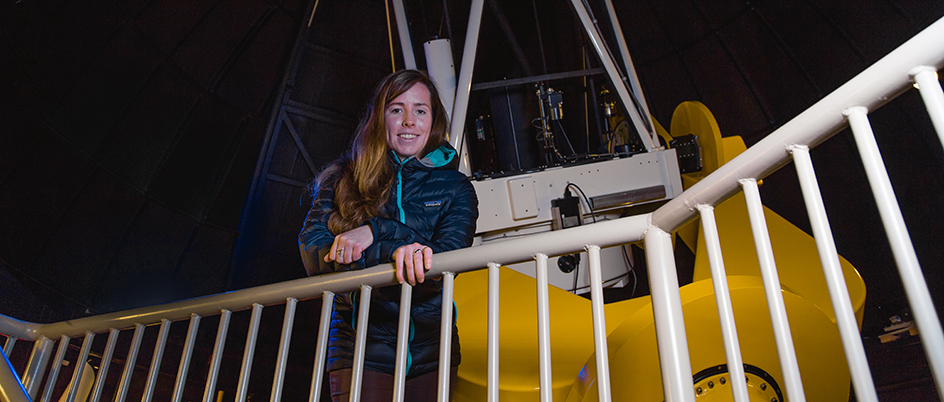 Graduate student Clare Higgs next to UVic's telescope