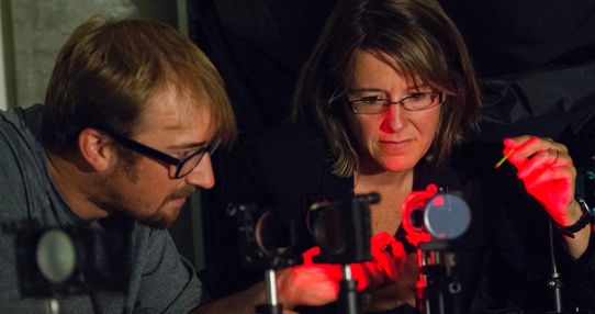 Two researchers working with adaptive optics components