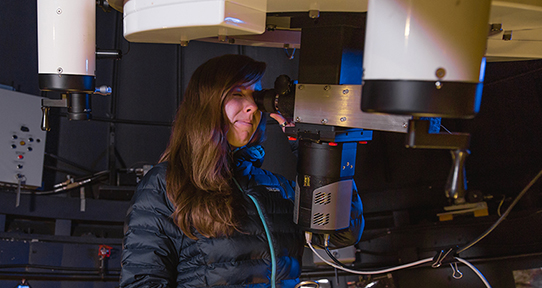 PhD candidate Clare Higgs looking through UVic's telescope