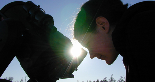 Person looking through a telescope