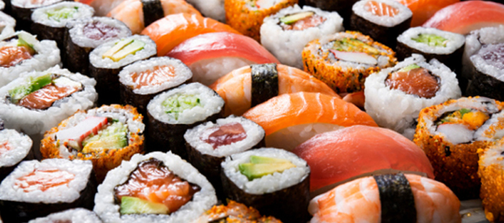 Assorted nigiri and maki on serving plates.