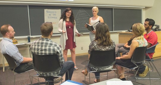 Workshop facilitators talking to a group of students